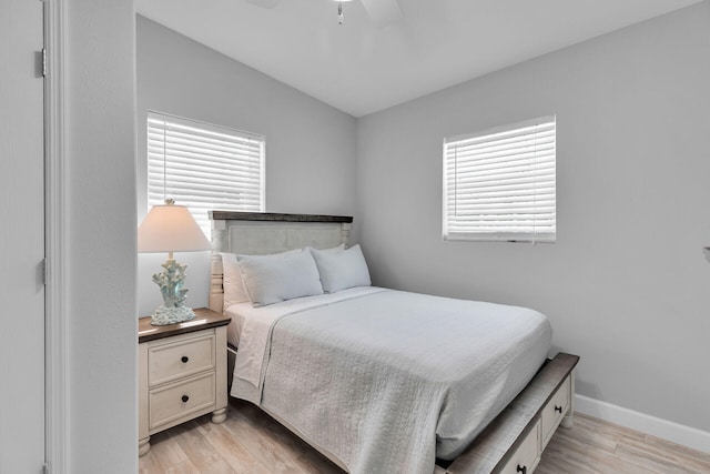 bedroom featuring light wood-type flooring, baseboards, and a ceiling fan