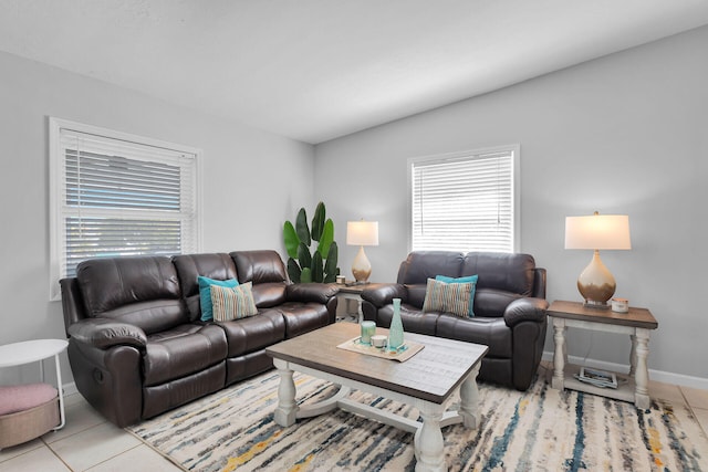 living room with light tile patterned floors, healthy amount of natural light, baseboards, and lofted ceiling