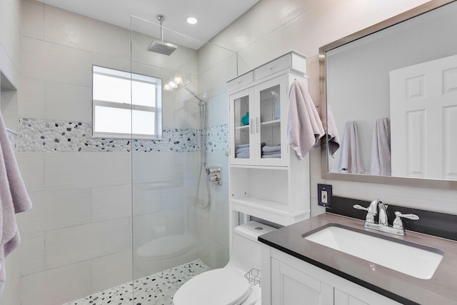 bathroom with a walk in shower, vanity, and toilet