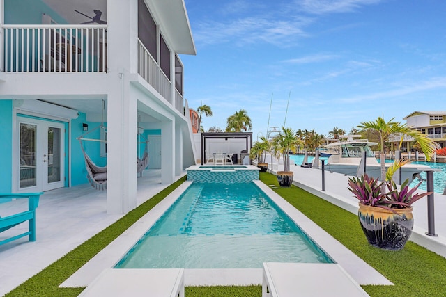 view of pool featuring french doors, a patio area, and a pool with connected hot tub