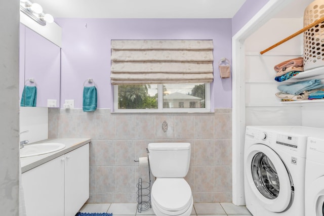 263 Azalea St, Tavernier, FL 33070 - bathroom featuring tile walls, washing machine and clothes dryer, tile patterned flooring, vanity, and a wainscoted wall