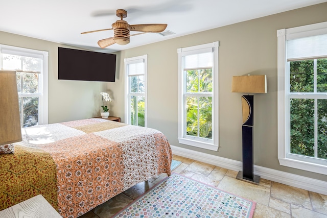 bedroom featuring visible vents, multiple windows, stone tile flooring, and baseboards