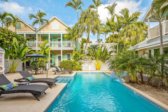 community pool featuring ceiling fan, fence, and a patio