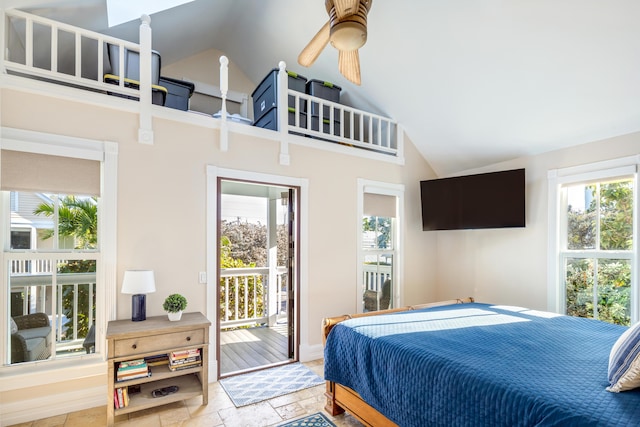 bedroom featuring baseboards, access to outside, high vaulted ceiling, and stone tile floors