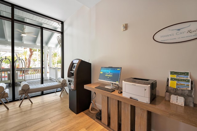 office area with light hardwood / wood-style flooring, expansive windows, and ceiling fan