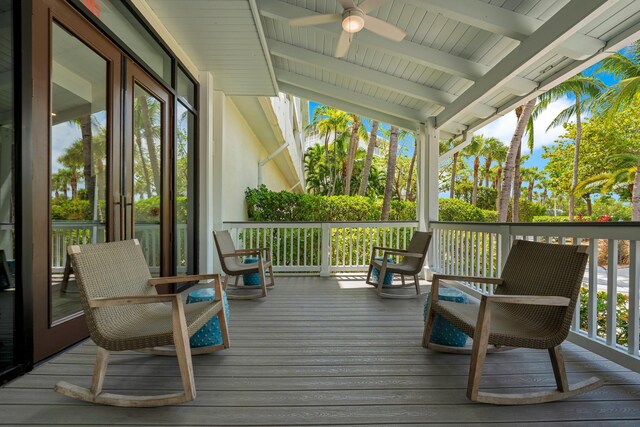 wooden terrace with ceiling fan and covered porch