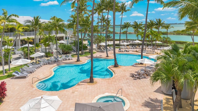 view of swimming pool with a community hot tub, a patio, and a water view