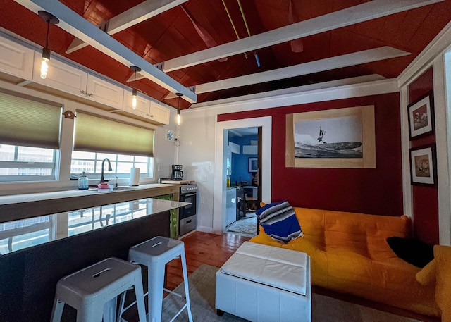 kitchen featuring sink, hanging light fixtures, hardwood / wood-style floors, a kitchen breakfast bar, and gas stove