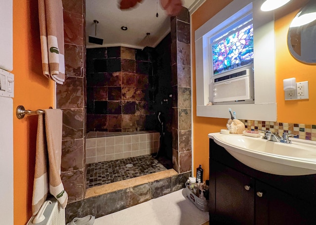 bathroom with vanity, decorative backsplash, and tiled shower