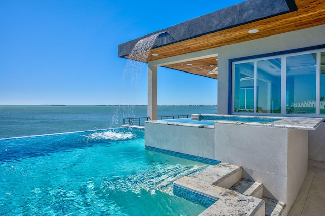 view of pool with a water view, pool water feature, and a jacuzzi