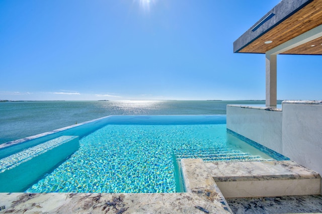 view of swimming pool featuring a water view