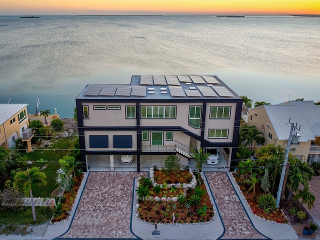 aerial view at dusk featuring a water view