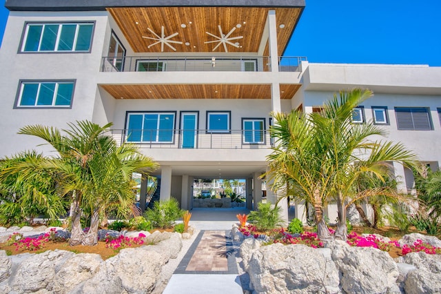 view of front of property with a balcony, a carport, and ceiling fan