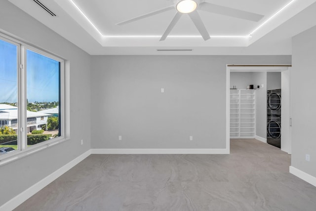 unfurnished room featuring stacked washer / dryer