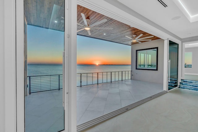 interior space featuring ceiling fan and a water view