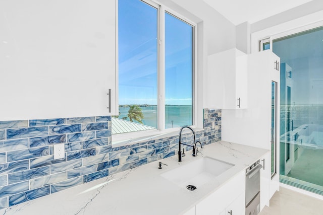 bathroom with vanity, walk in shower, tasteful backsplash, and a water view