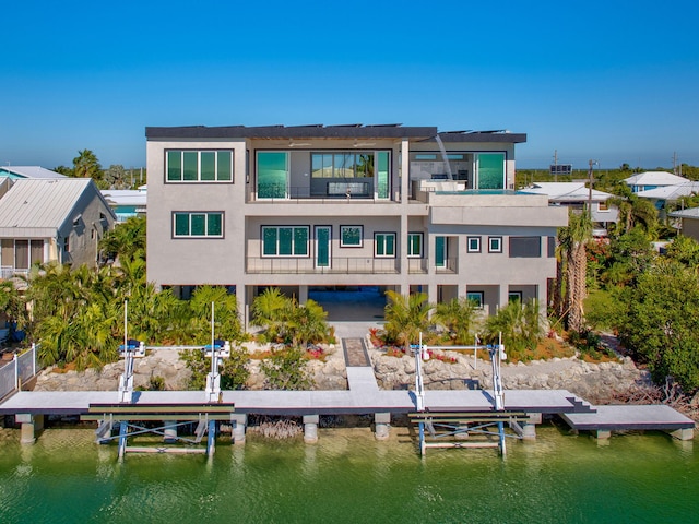 back of house featuring a water view and a balcony