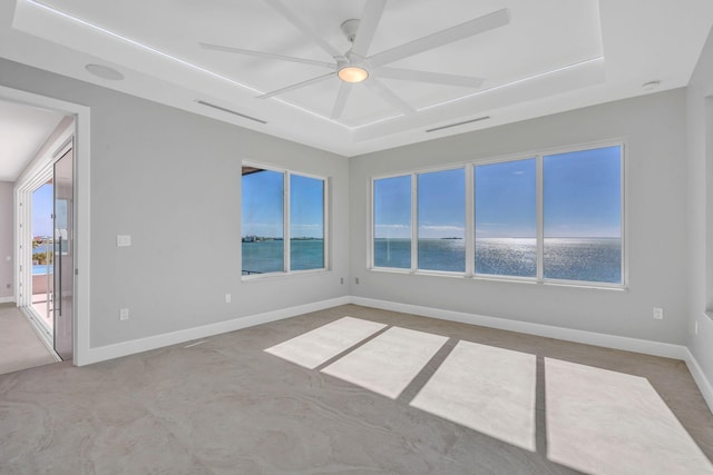 unfurnished room featuring a water view and ceiling fan