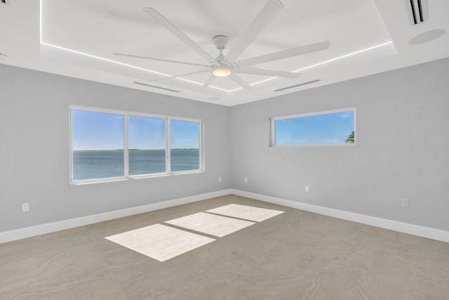 unfurnished room featuring a water view and ceiling fan