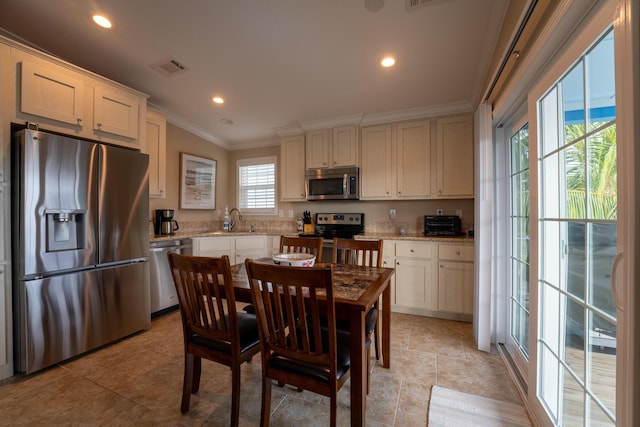 kitchen featuring white cabinetry, sink, ornamental molding, light stone counters, and stainless steel appliances