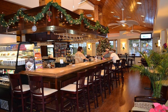 bar featuring dark wood-type flooring, lofted ceiling, wood ceiling, and ceiling fan