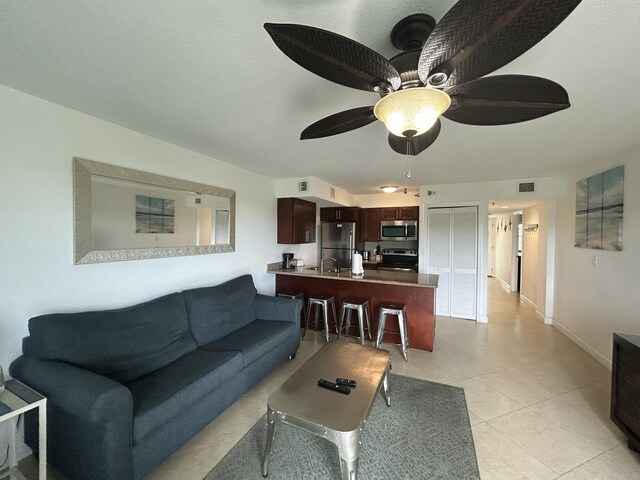 tiled living room featuring ceiling fan