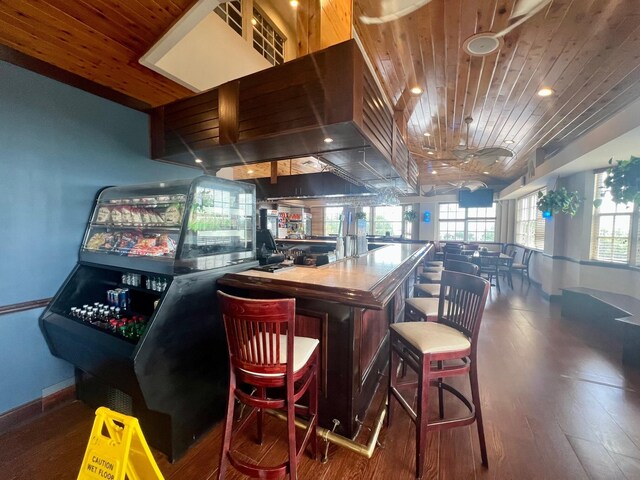 bar with dark wood-type flooring and wooden ceiling