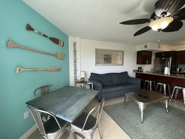 tiled living room featuring ceiling fan and sink