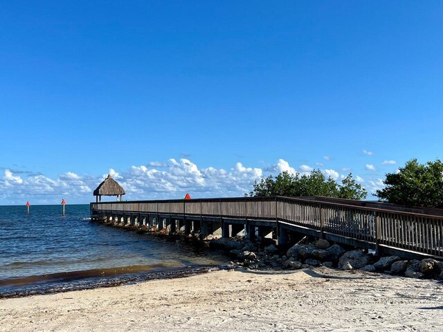 dock area featuring a beach view and a water view