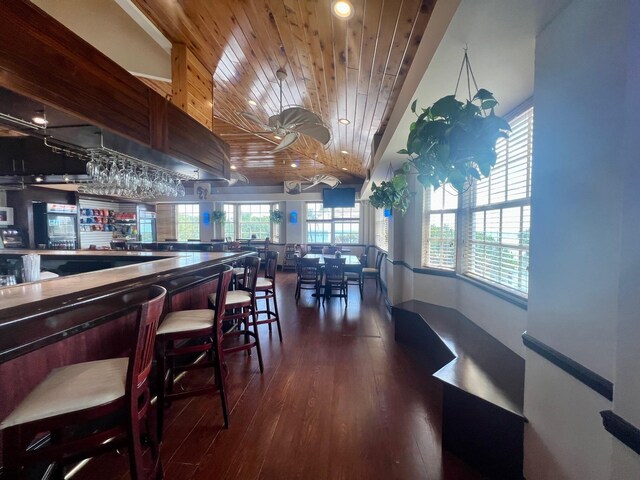 dining space with lofted ceiling, dark hardwood / wood-style floors, and wooden ceiling