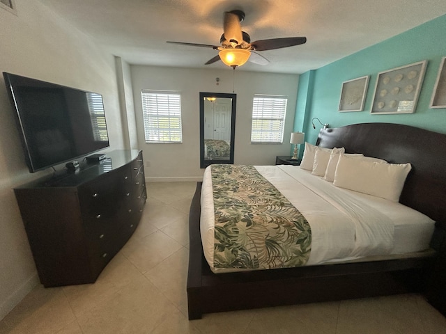 bedroom with ceiling fan, a closet, and light tile patterned floors