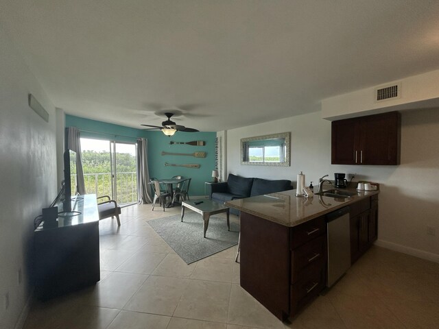 kitchen with sink, light tile patterned floors, ceiling fan, dark brown cabinetry, and stainless steel dishwasher