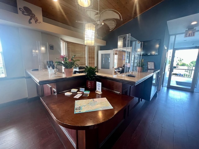 interior space featuring dark wood-type flooring, a breakfast bar area, and vaulted ceiling