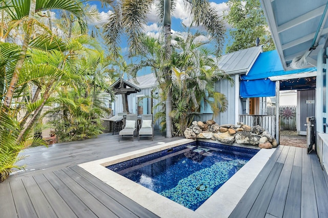 view of pool with a hot tub and a deck