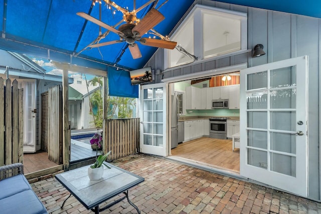 unfurnished sunroom featuring ceiling fan and vaulted ceiling