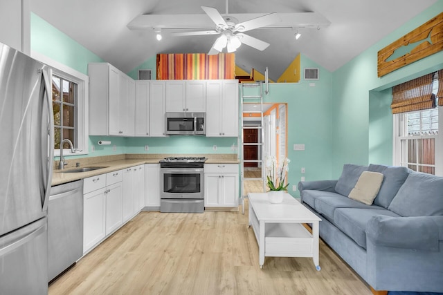 kitchen with light wood finished floors, visible vents, appliances with stainless steel finishes, open floor plan, and a sink