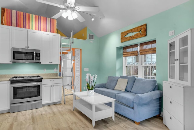 living room with lofted ceiling, light wood-type flooring, visible vents, and a ceiling fan