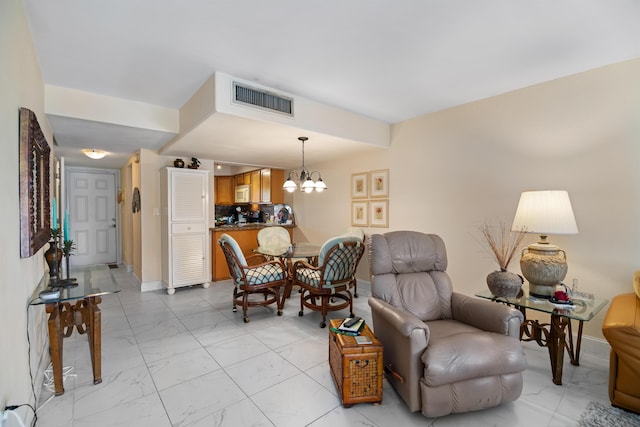 interior space featuring marble finish floor, visible vents, a notable chandelier, and baseboards