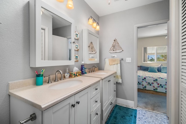 bathroom with double vanity, baseboards, and a sink