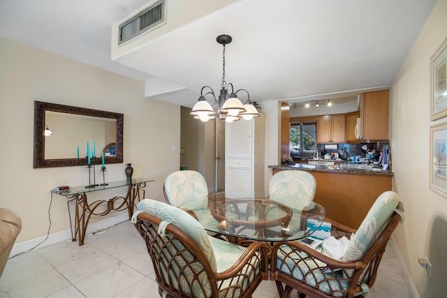 dining space with marble finish floor, an inviting chandelier, visible vents, and baseboards