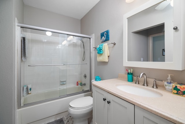 bathroom with vanity, toilet, and bath / shower combo with glass door