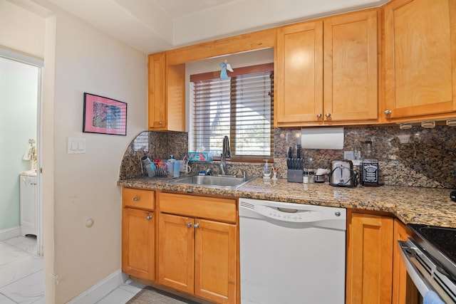 kitchen with baseboards, dishwasher, backsplash, stone counters, and a sink