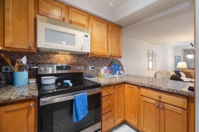 kitchen featuring tasteful backsplash, stone countertops, white microwave, a peninsula, and stainless steel range with electric cooktop