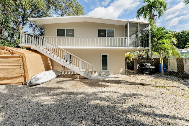 rear view of house featuring a patio and a sunroom