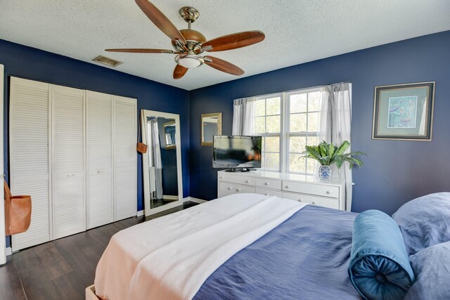 bedroom featuring ceiling fan, dark hardwood / wood-style floors, a textured ceiling, and a closet