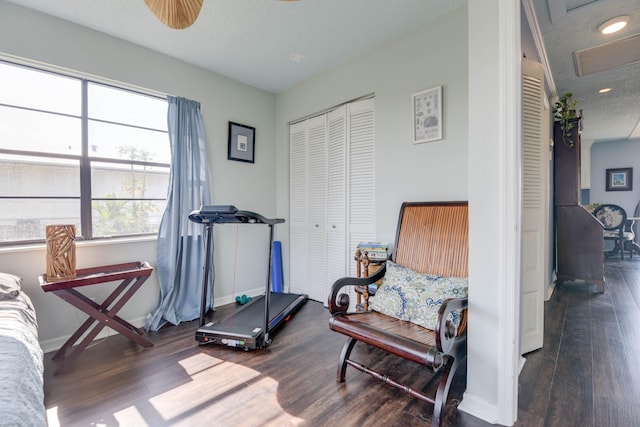 workout area with dark wood-type flooring and a textured ceiling