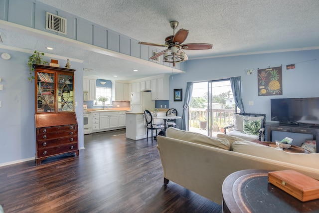 living room featuring dark hardwood / wood-style flooring, crown molding, and a textured ceiling