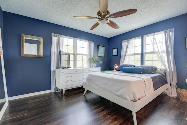 bedroom featuring ceiling fan, a textured ceiling, and dark hardwood / wood-style flooring