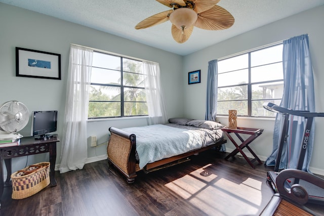 bedroom featuring ceiling fan, a textured ceiling, and dark hardwood / wood-style flooring