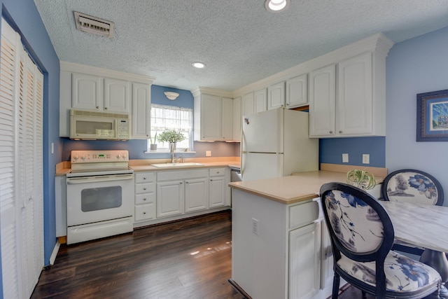 kitchen with sink, white cabinetry, dark hardwood / wood-style floors, kitchen peninsula, and white appliances